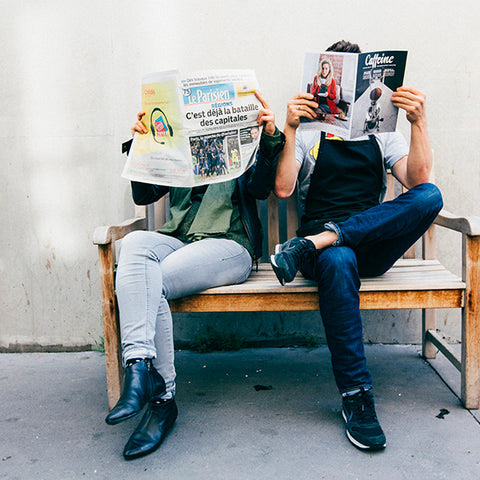 Deux lecteurs sur un banc patiente devant un coffee shop