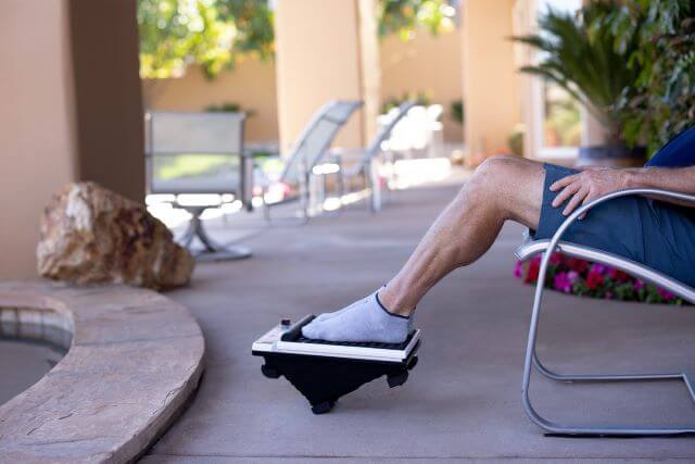 Person resting feet on the MedMassager MMF07 foot massager.