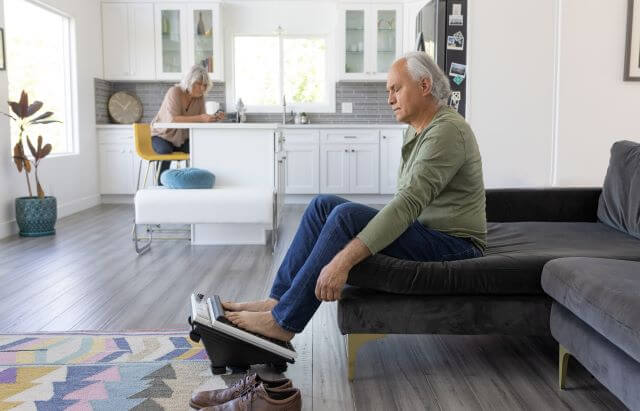 Man resting his feet on oscillating massager.