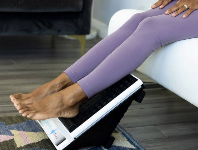 Person resting calf muscles on vibrating foot massager.