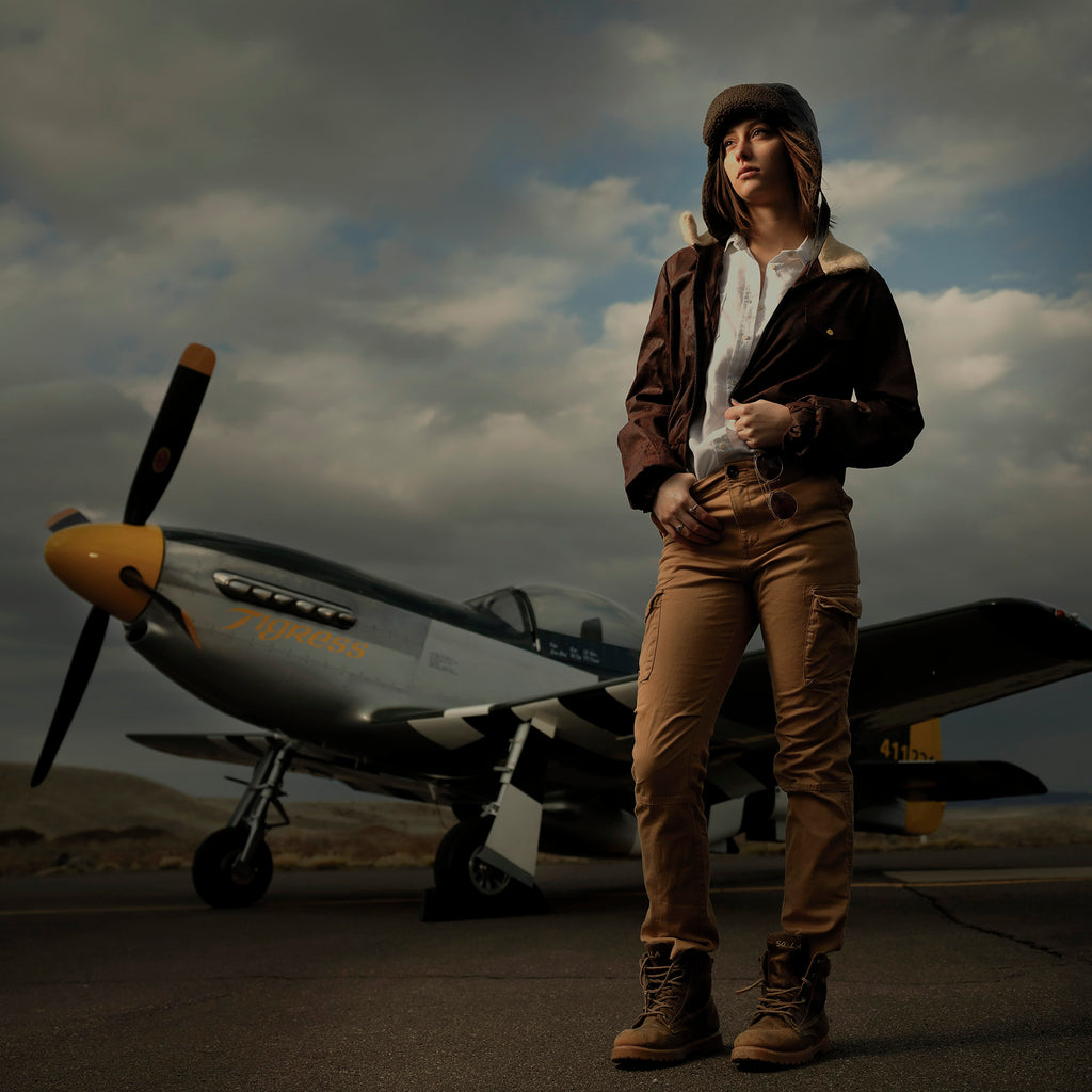 Bruce Dorn model fighter pilot wearing bomber jacket airplane in background
