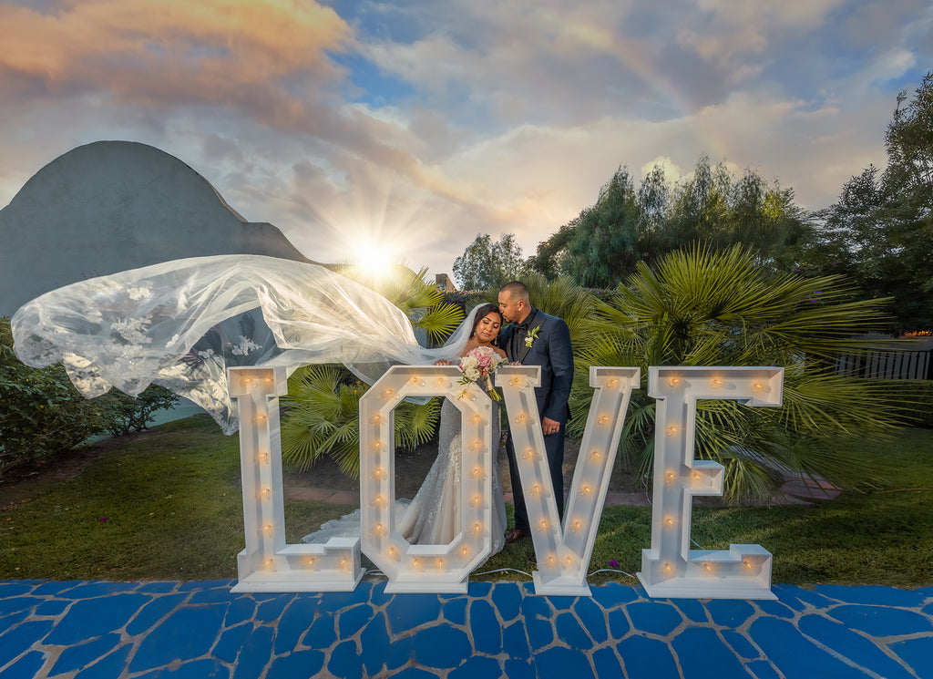 Ellie Burgueno Chico_wedding couple with LOVE sign and rainbow