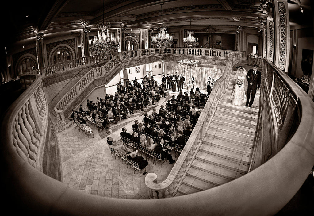 Greg Gibson wide angle bride and father walking down staircase with view of ceremony