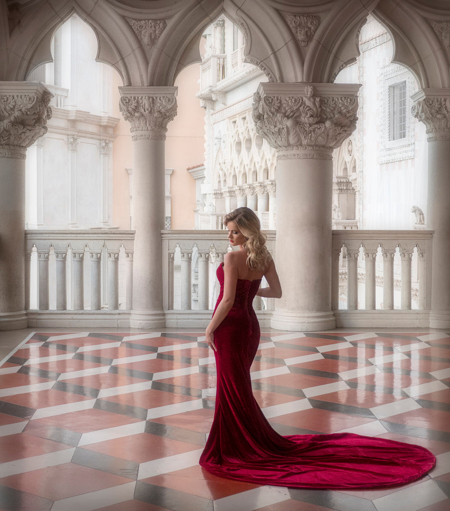 James Schmelzer Woman wearing red dress standing on checkered tile with arabesque style columns