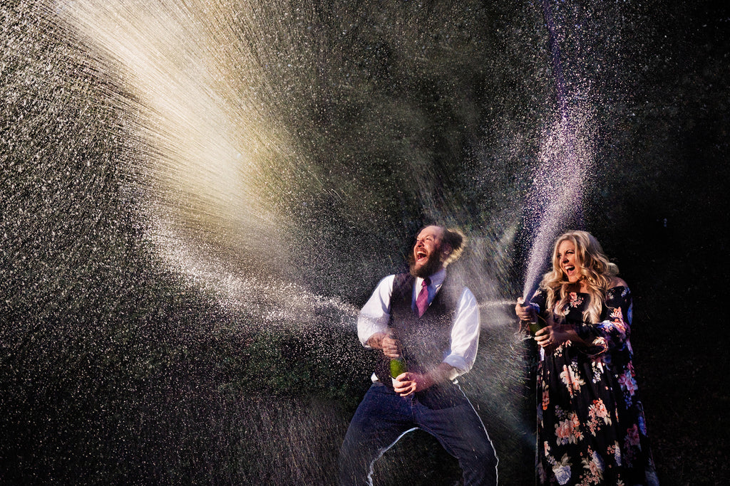 Jason Vinson man and woman celebrating spraying champagne