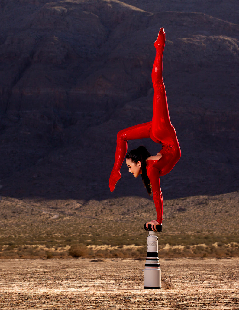 Jerome Hamilton contortionist in red leotard hand balancing on large lens 