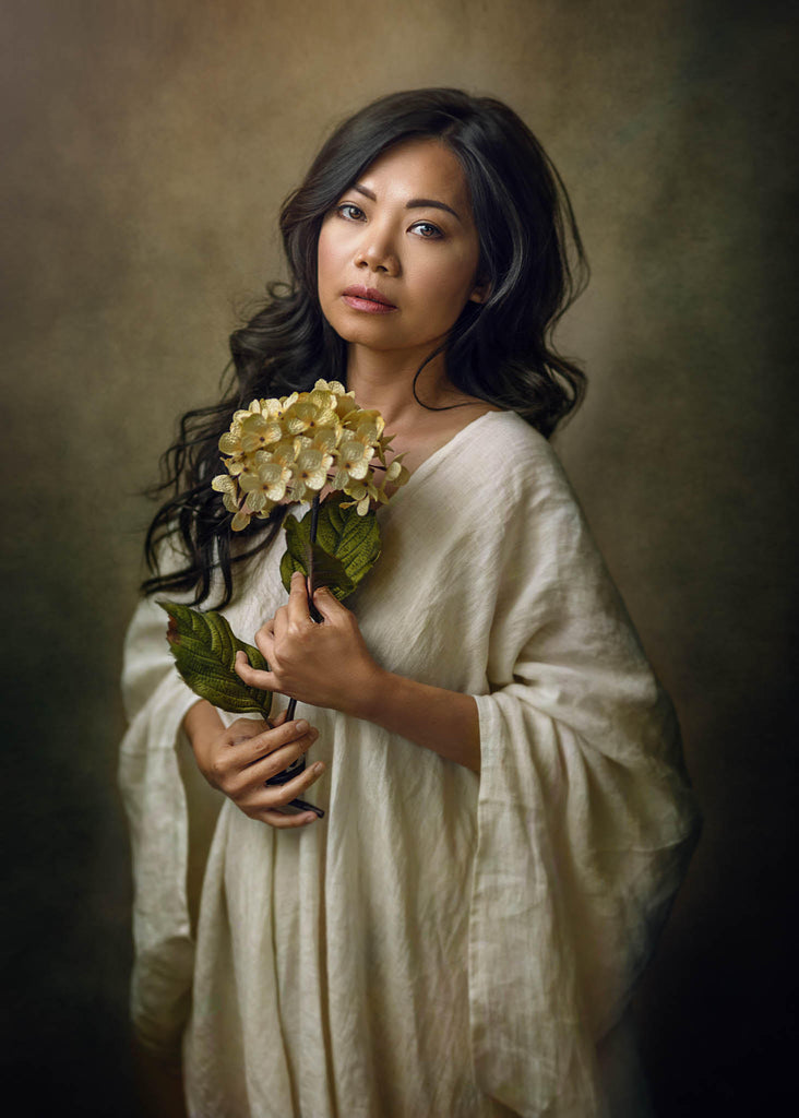 Leon Johnson portrait of Asian woman wearing white holding flowers light hydrangea