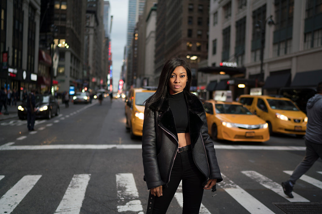 Sara France photograph of woman in New York City crosswalk wearing black leather jacket yellow taxi cabs in background
