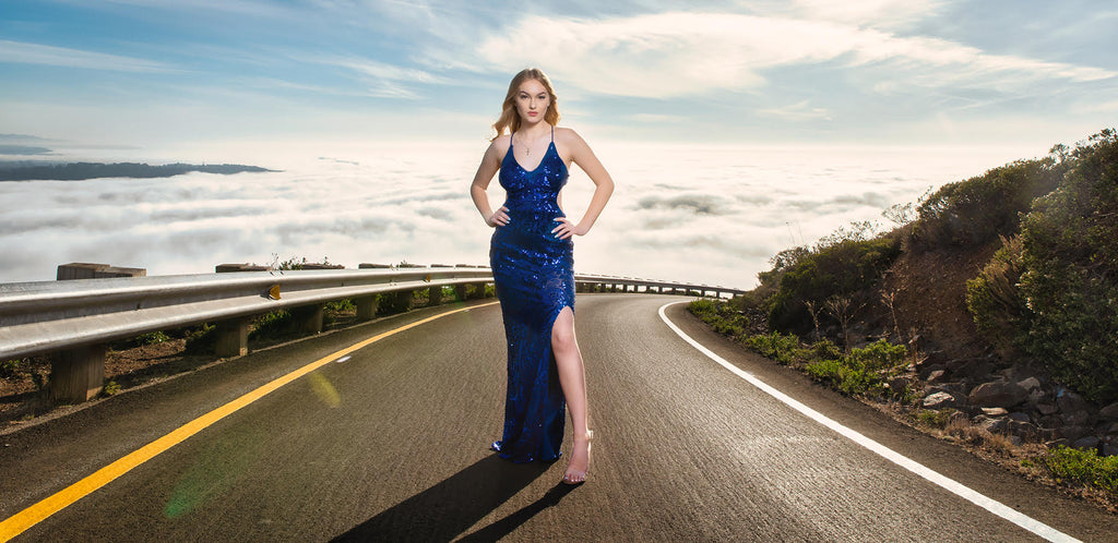 Steve Batz portrait of woman on road blacktop in blue dress high heels blue sky