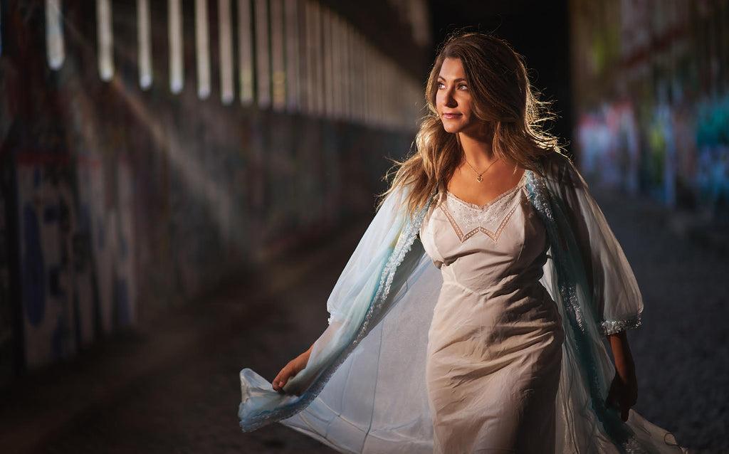 Steve Batz woman in white dress in old abandoned railway tunnel light streaking