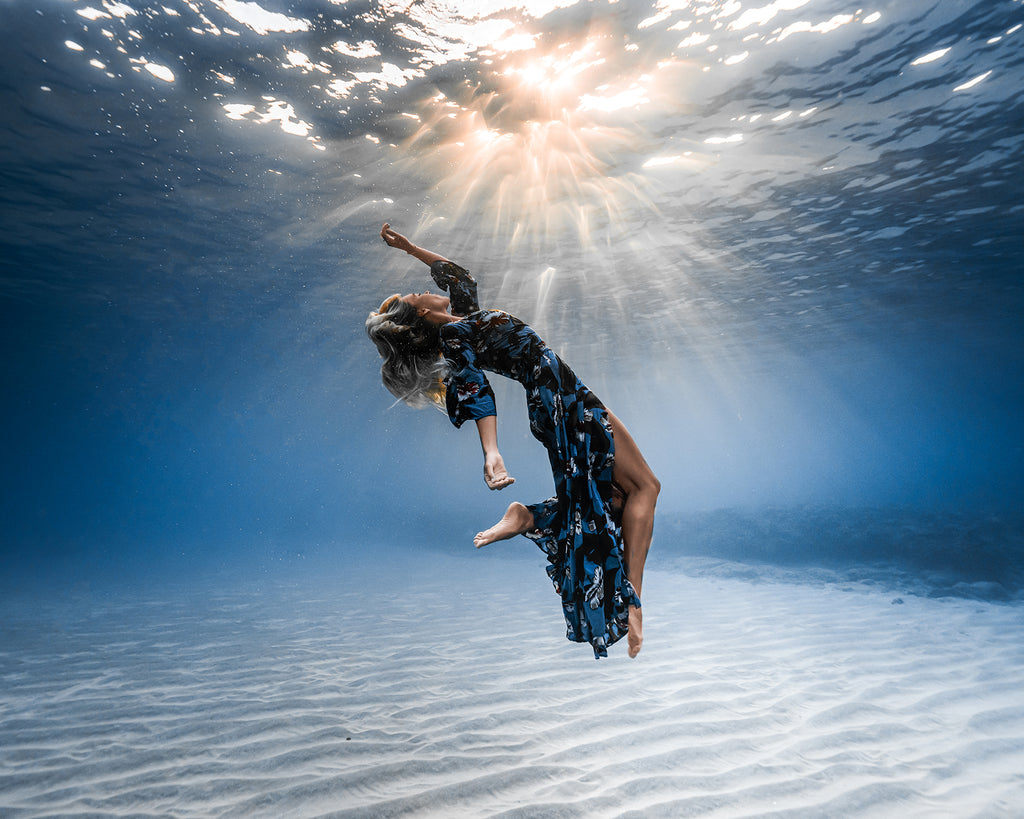 Terry Flanagan woman in dress floating underwater near seafloor