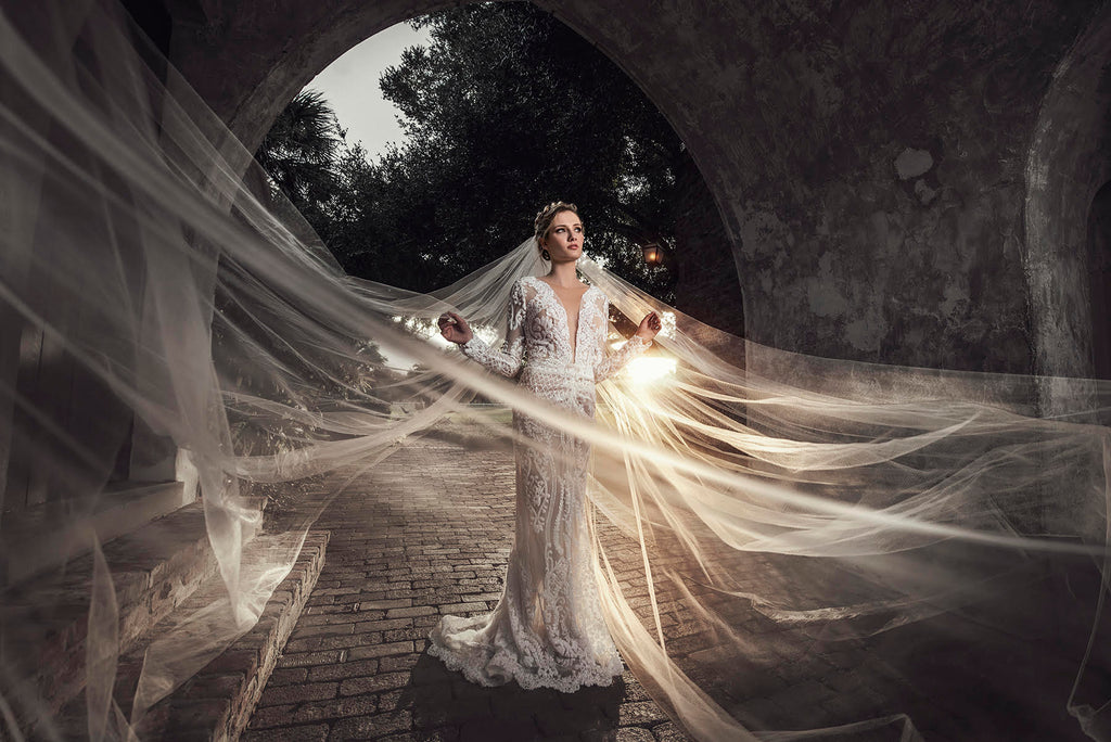 Yuliya Panchenko bride with large veil with sunlight in archway tunnel