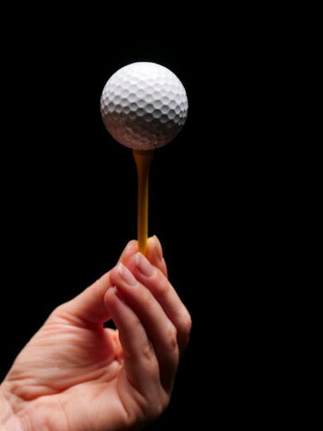 A person holding a golf ball