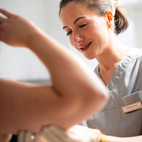 Der Arm der Patientin wird von Kasia nach der Fett-weg-Spritze massiert