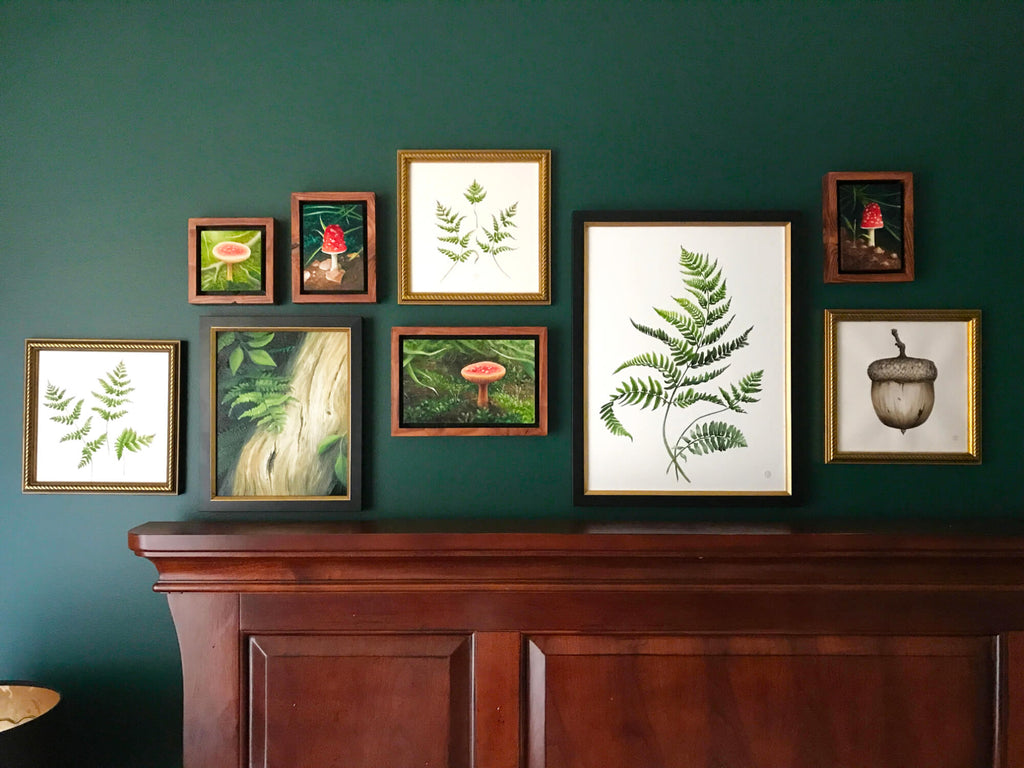 Woodland paintings hanging in a gallery wall