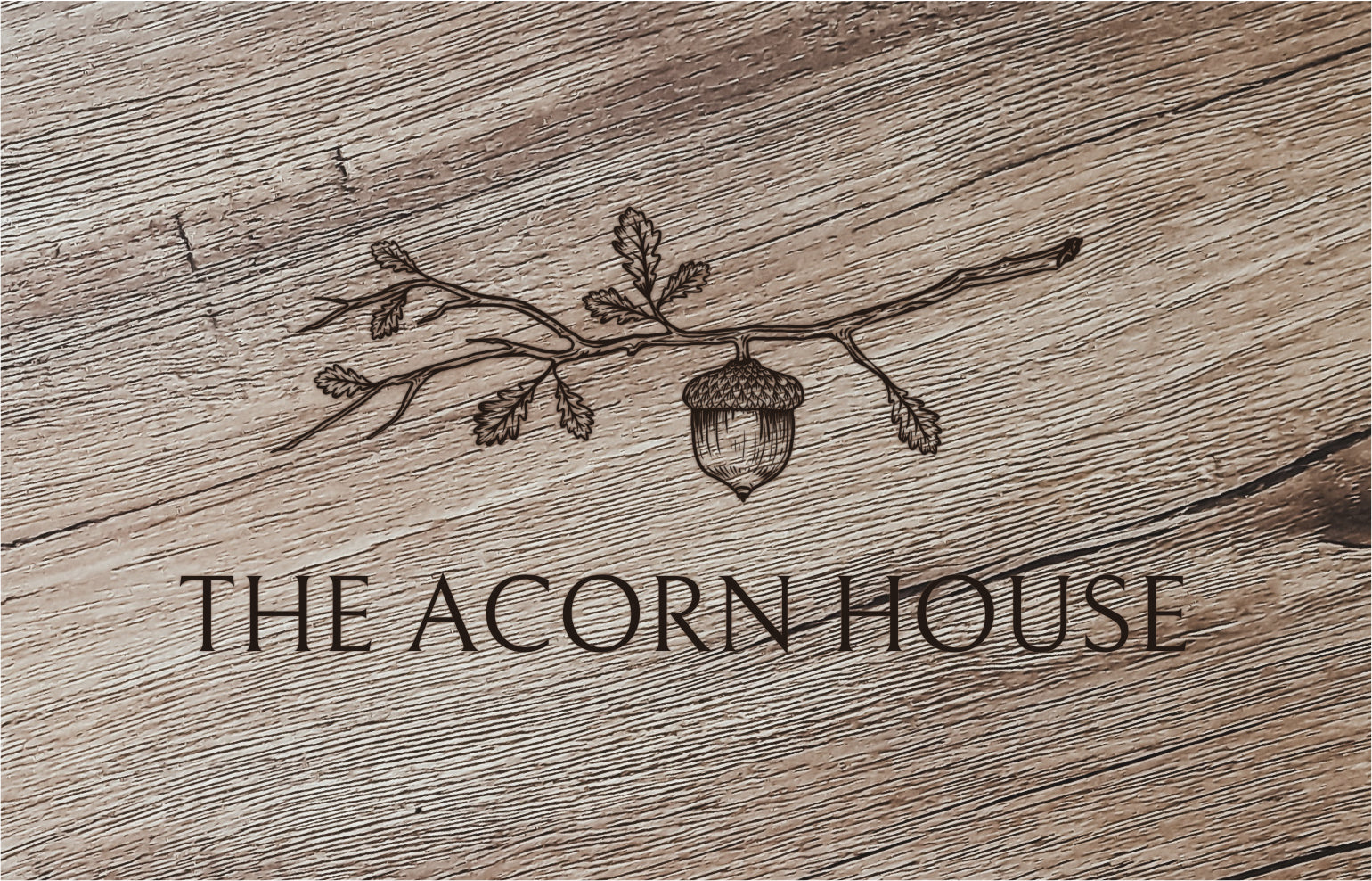 the acorn house logo on wood background