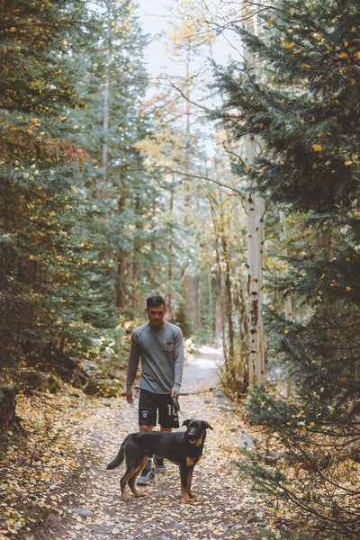 man walking dog in the woods