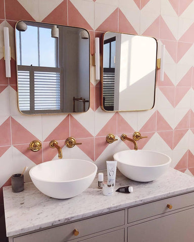 White and pink bathroom with brass taps