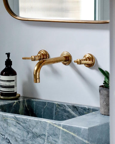 Modern bathroom basin with brass taps and marble sink