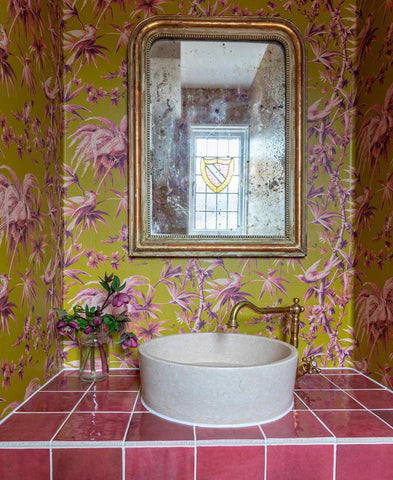 Unique bathroom with colourful wallpaper and brass taps