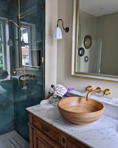Bathroom with unlaquered brass taps over basin