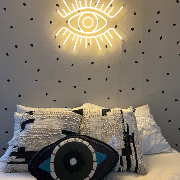 Warm White Eye neon sign above bed
