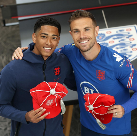 Jude Bellingham and Jordan Henderson with their England Football Caps in front of our ping pong table