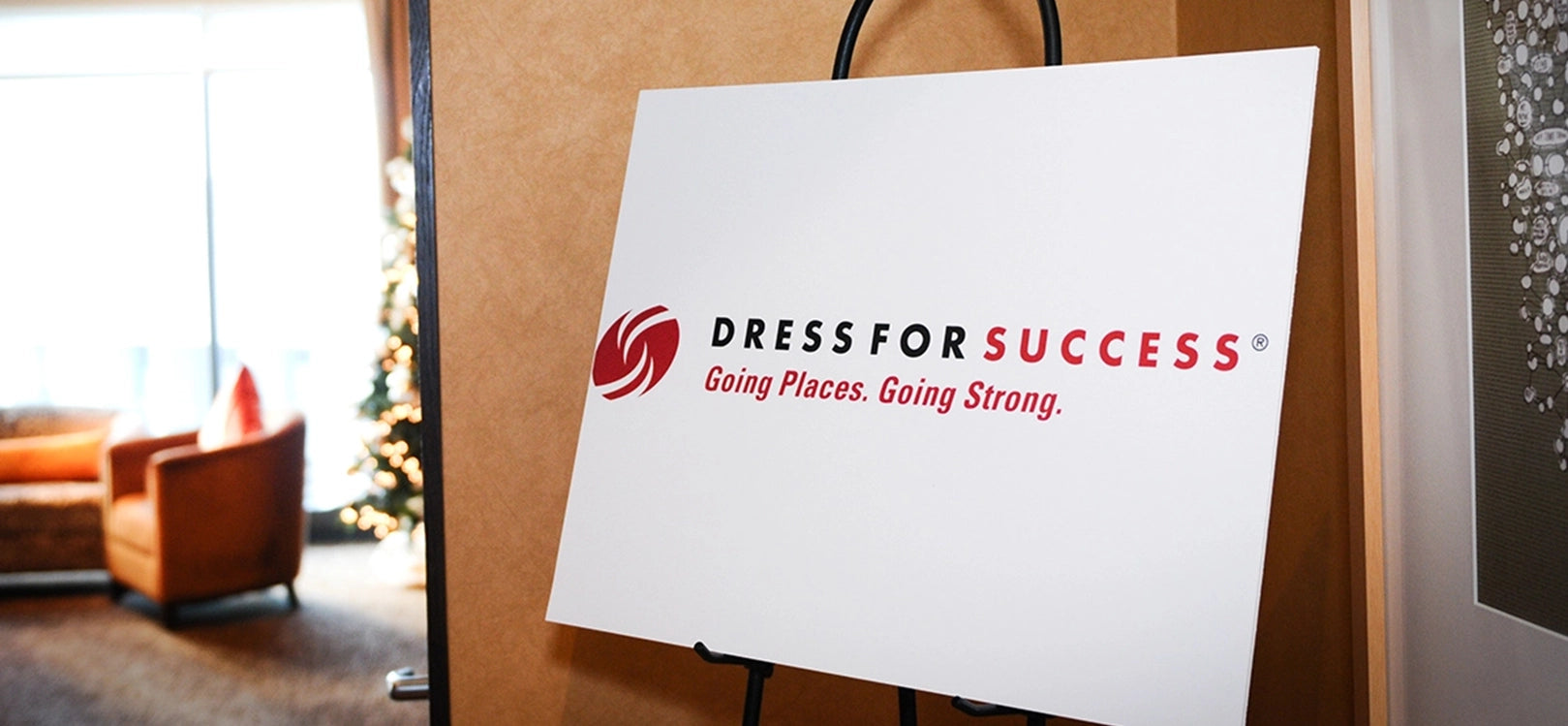 Conference room with white sign that says "Dress For Success | Going Places. Going Strong" in red text