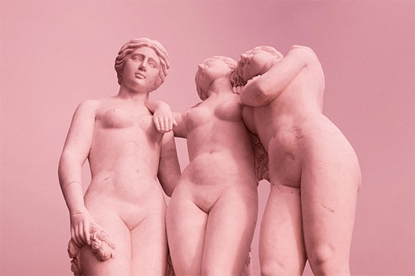 Three pink statues of naked women against pink background