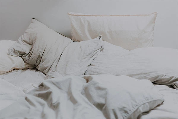 Cream white pillows on messy bed