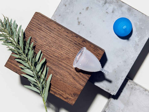 Two Lunette menstrual cups lying on a stone block.