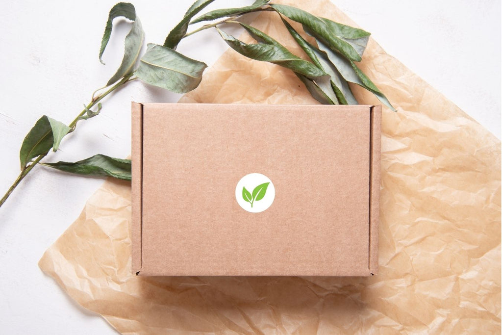 A brown packaging box on a table with brown paper, a small branch of leaves and a Reuseful leaf logo.