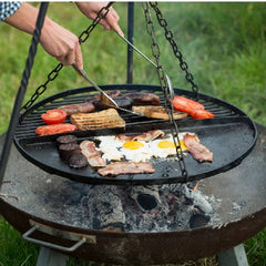Cooking up a breakfast feast on a hanging grill over an open fire pit