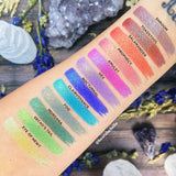 Top angled arm swatches on fair skin tone of Witchcraft vs. Alchemy Collection including Hex Duochrome Eyeshadow
