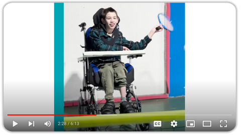 YouTube Video snapshot of boy playing tennis in a powered wheelchair.