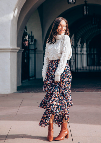 Women in white turtleneck, maxi skirt, and brown leather boots