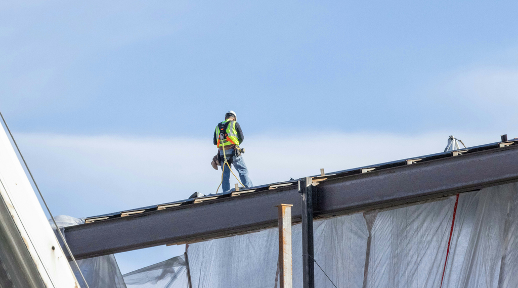 Trabajador de la construcción con equipo de seguridad para techos.