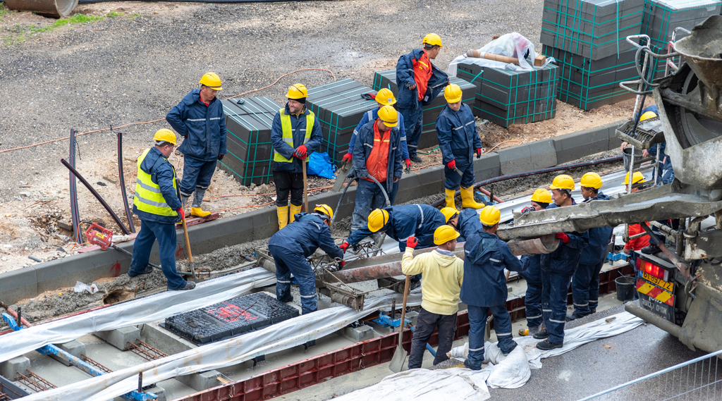 Trabajadores de la construcción usan EPP para evitar quemaduras de concreto