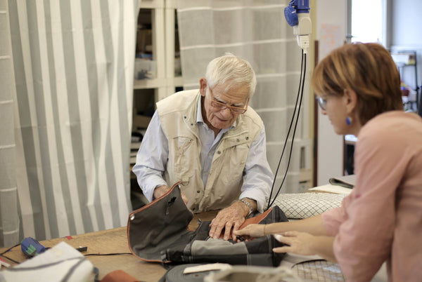 elderly man looking at a brown tote bag