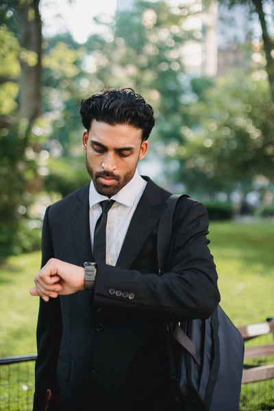 man in a suit looking at his watch