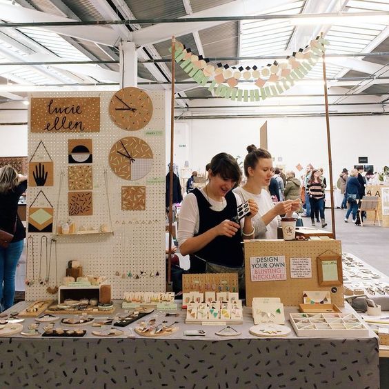 two woman at a fair stand with their products