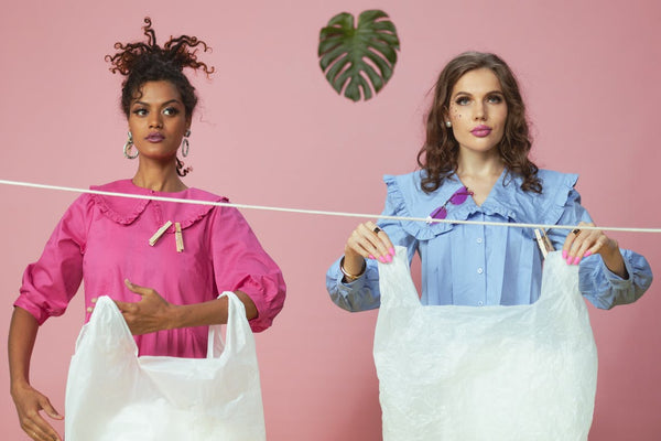 two women hanging up plastic bags