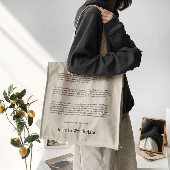 woman holding a white printed tote bag