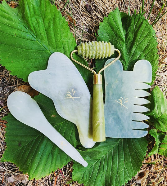 Yin Your Skin Gua sha-verktyg på gröna blad