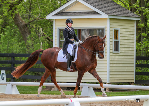 Jessica riding her intermediare 1 dressage horse at a horse show