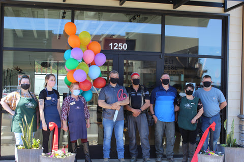 Group of happy Face Rock employees at the entrance of the Cafe at Coos Bay Village