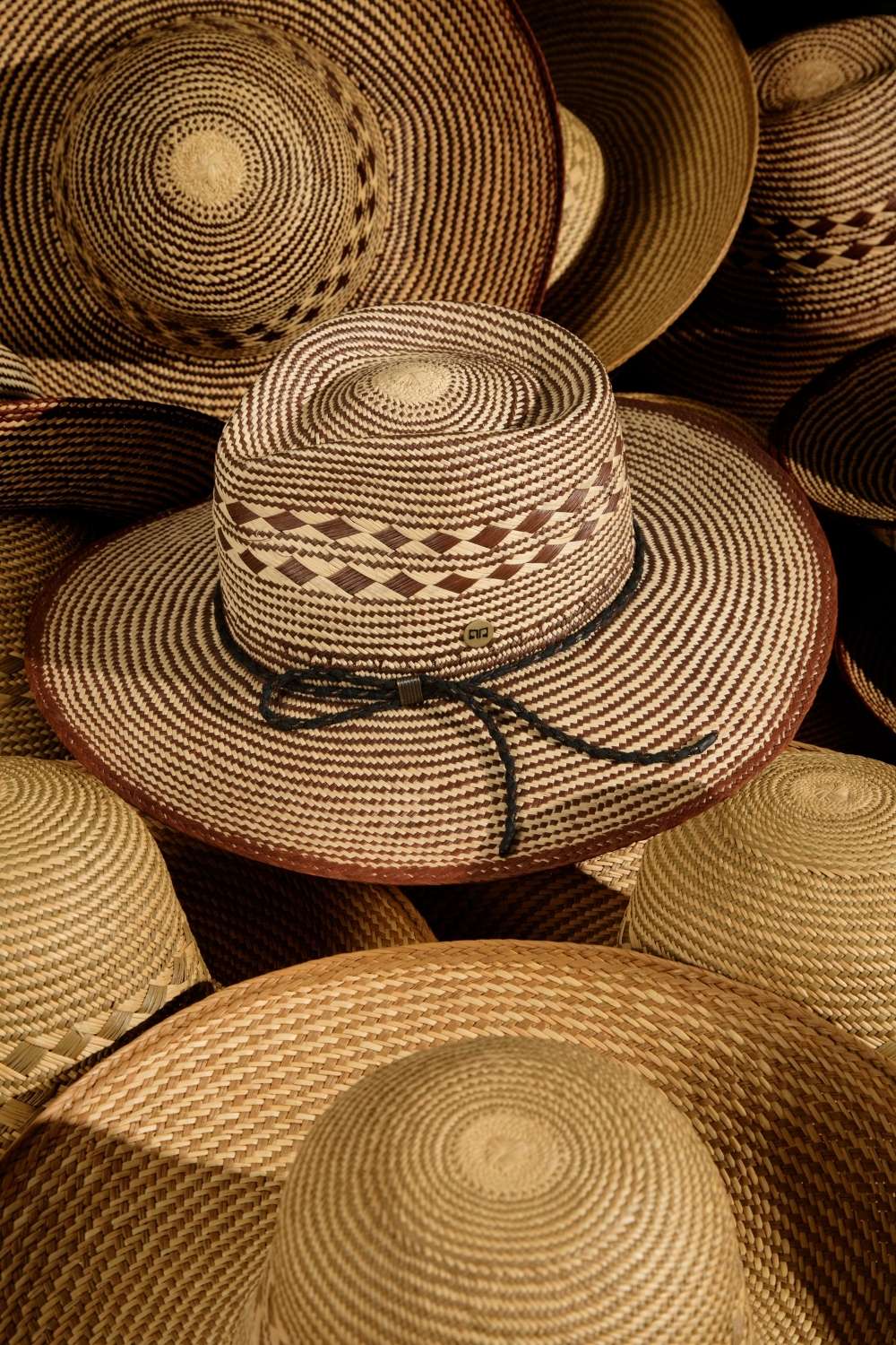 still life scuro Cappello originale in paglia Panama Ecuador da uomo. Copricapo artigianale maschile in stile cowboy o western texano simile modello fedora con tesa/falda larga.