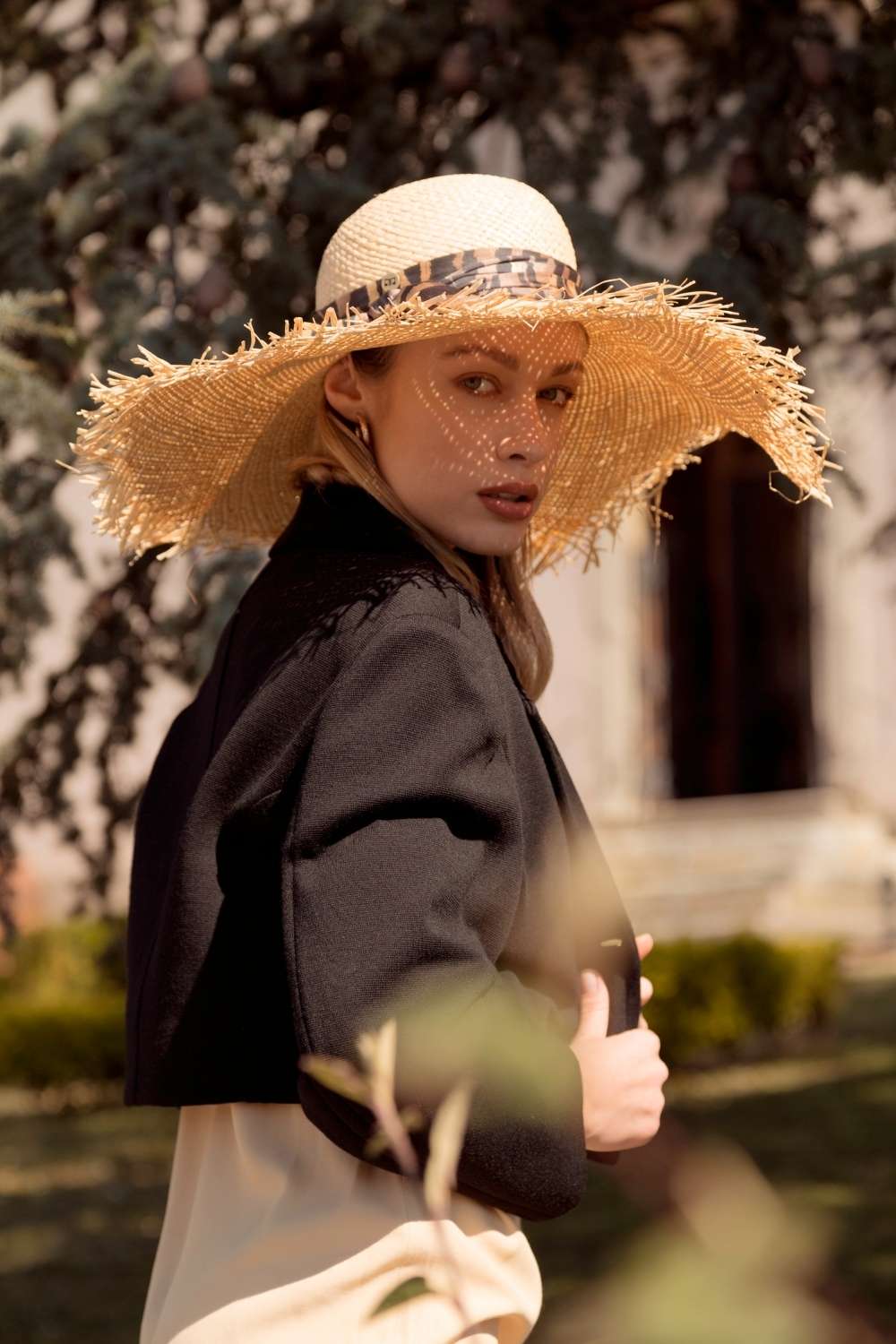 Cappello di paglia estivo a tesa larga da donna. Copricapo da spiaggia alla moda con nastro in satin e falda ampia. Cucito a mano da artigiani esperti in Toscana.