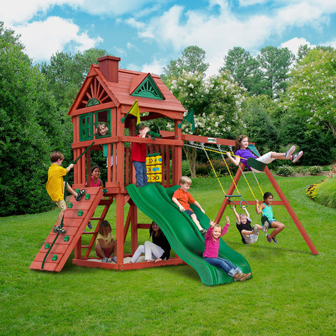 Gorilla Double Down II Swing Set in a lush garden setting with children playing on swings, slide, and rock climbing feature.