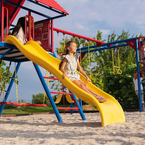 A child enjoying the yellow slide on the Lifetime Big Stuff Deluxe Swing Set.